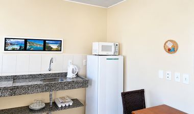 Cozinha do apartamento com geladeira e micro-ondas