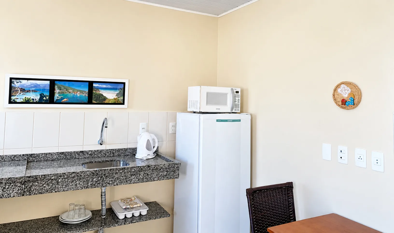 Cozinha com geladeira e micro-ondas em apartamento da pousada