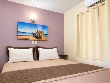 Quarto de casal com quadro de barco